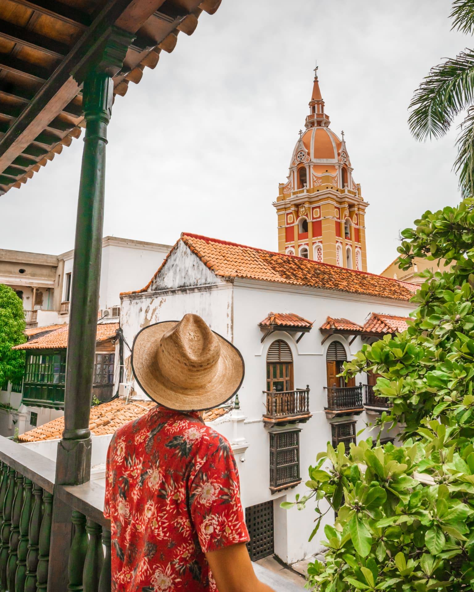 Viajante observando a catedral de Cartagena a partir de um balcão colonial
