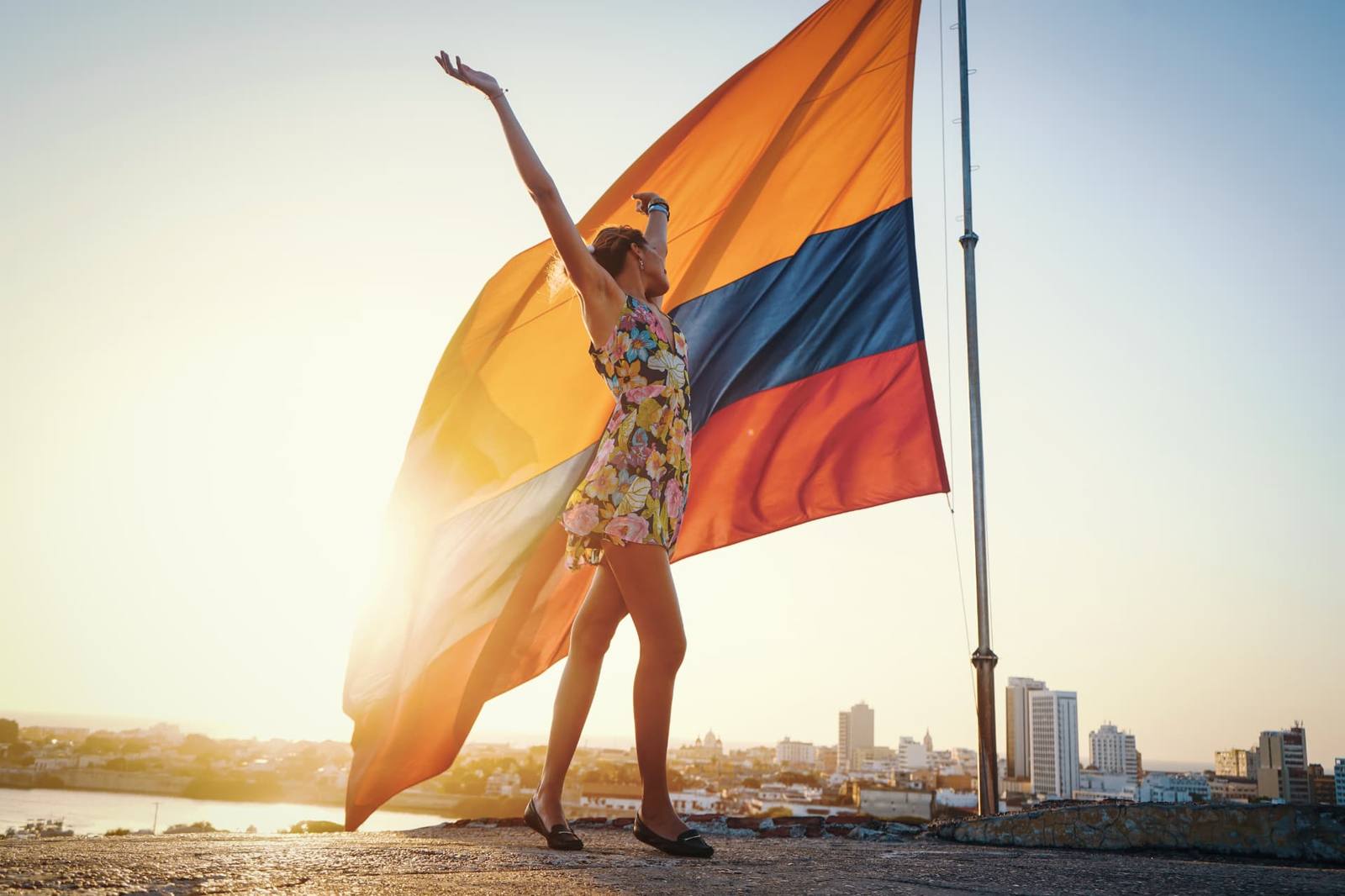Viajante com a bandeira da Colômbia ao pôr do sol em Cartagena