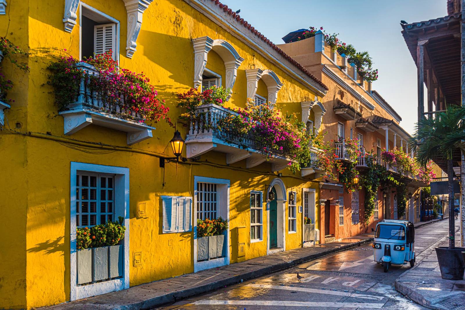 Rua colonial amarela com flores na Cidade Murada de Cartagena