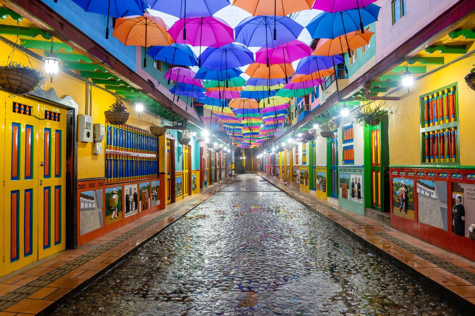 Rua colorida com guarda-chuvas suspensos na Colômbia